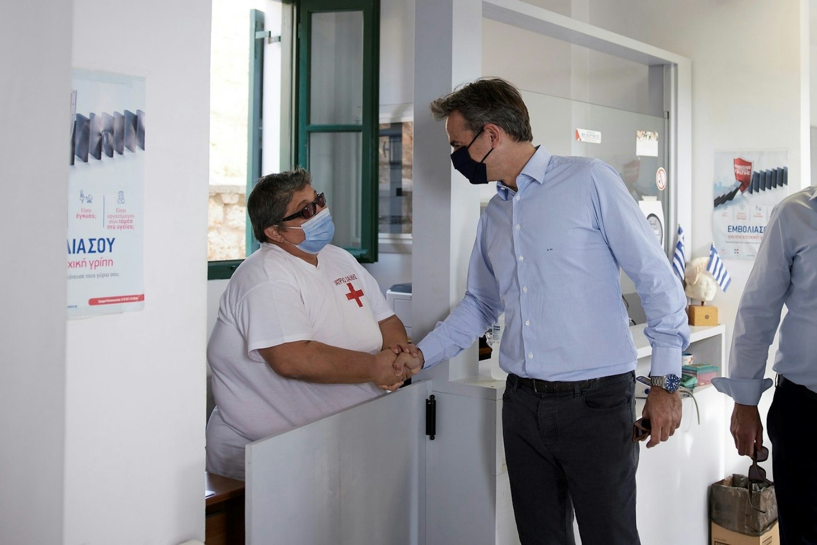 Greece’s Prime Minister Kyriakos Mitsotakis greeting a health worker in Chalki